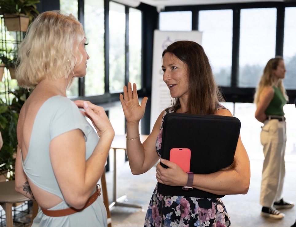 Carly Woods speaking with an attendee during a live workshop